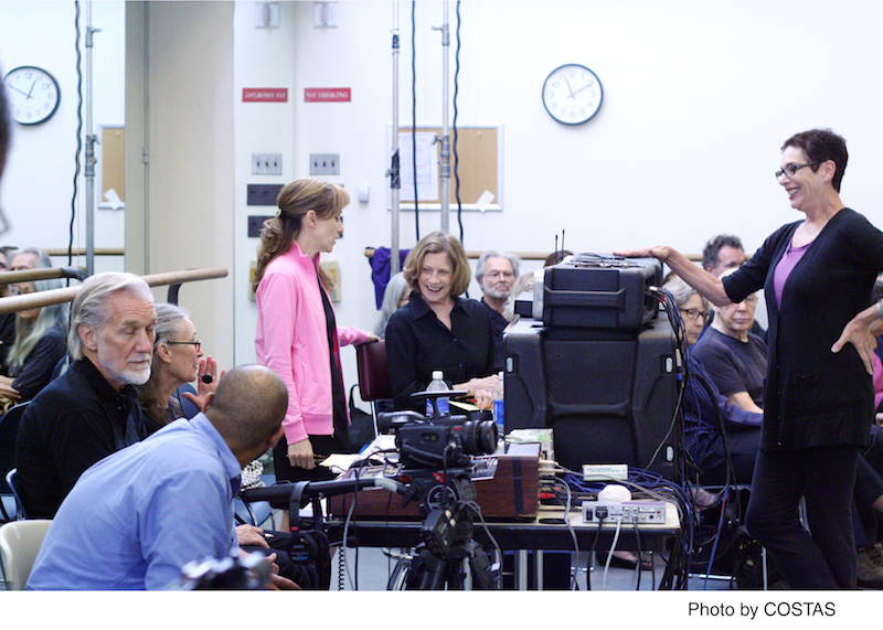 A film crew congregates around Reynolds admist speakers, cords and camera equipment